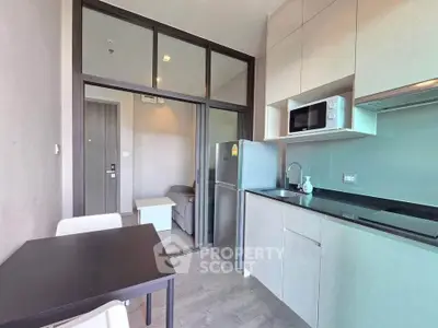 Modern kitchen with sleek cabinetry and stainless steel appliances in a stylish apartment.