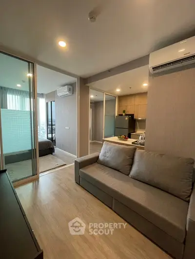 Modern open-plan living room with kitchen and bedroom in a stylish apartment.