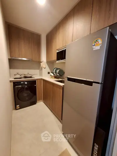 Modern compact kitchen with sleek appliances and wooden cabinetry