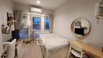 Cozy bedroom with modern decor, featuring a desk, bed, and large window for natural light.