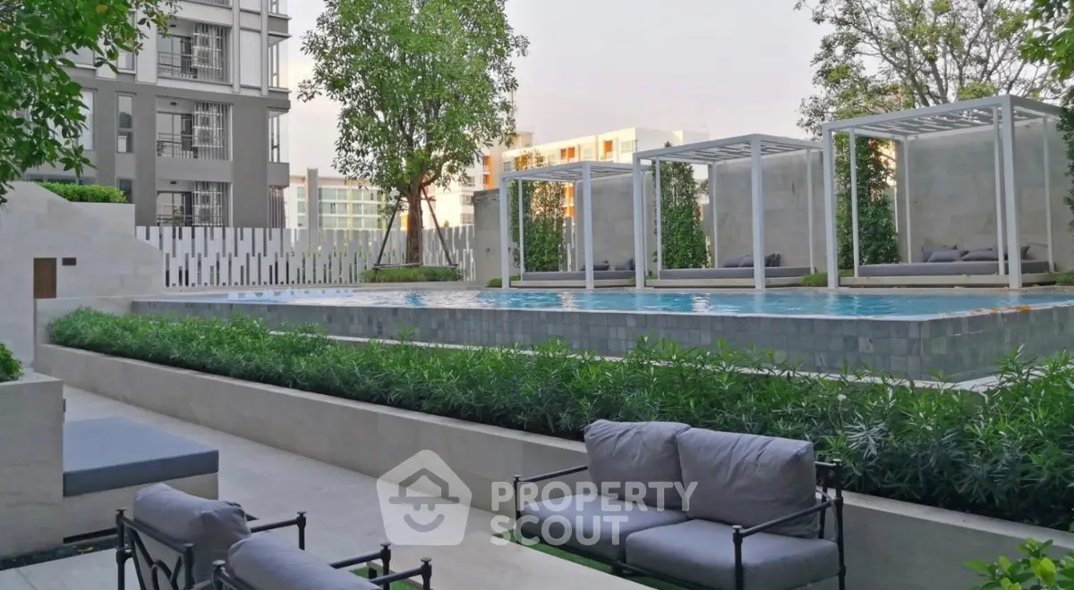 Luxurious outdoor pool area with modern cabanas and lush greenery in a high-end residential complex.