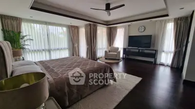 Spacious bedroom with elegant decor and large windows for natural light