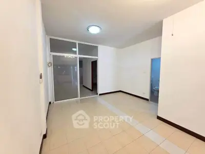 Spacious unfurnished room with tiled flooring and bright lighting, ideal for customization.