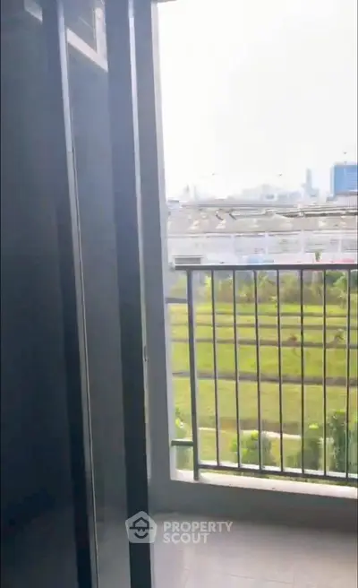 Modern balcony with scenic view of green fields and city skyline, perfect for relaxation.