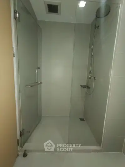 Modern bathroom with glass shower enclosure and sleek fixtures