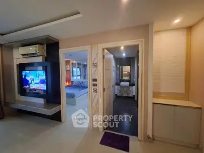 Modern living space with TV, air conditioning, and view into bedroom and bathroom.