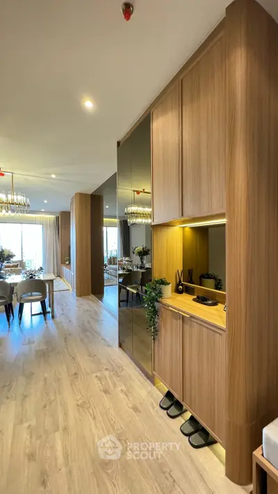 Luxurious open-plan living and dining area with elegant wooden cabinetry and modern decor.