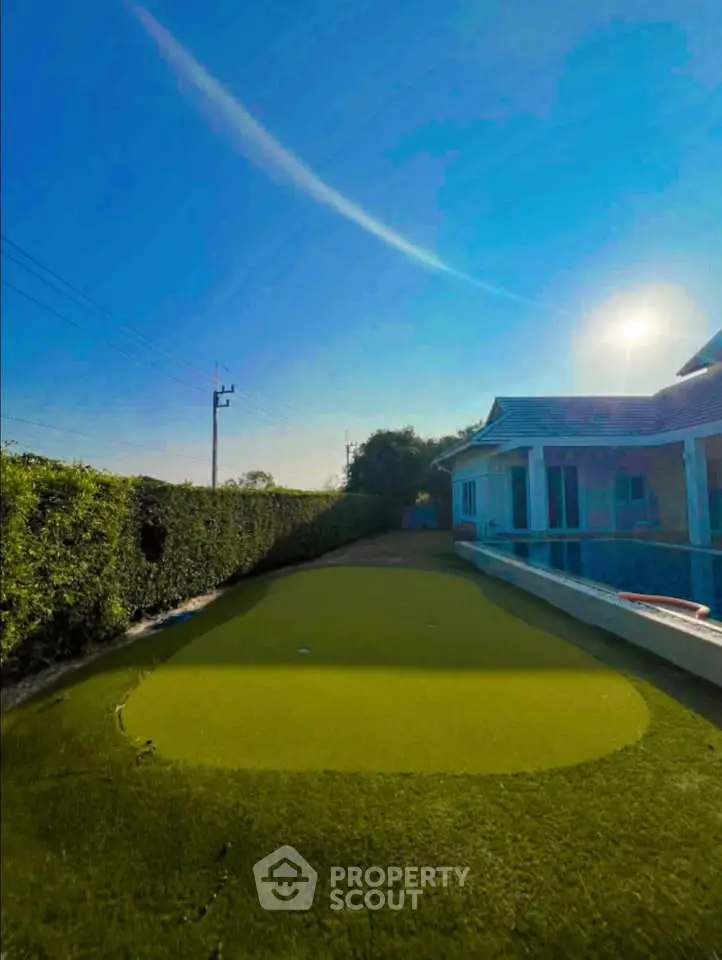 Luxurious home with private putting green and lush garden, perfect for golf enthusiasts seeking tranquility.