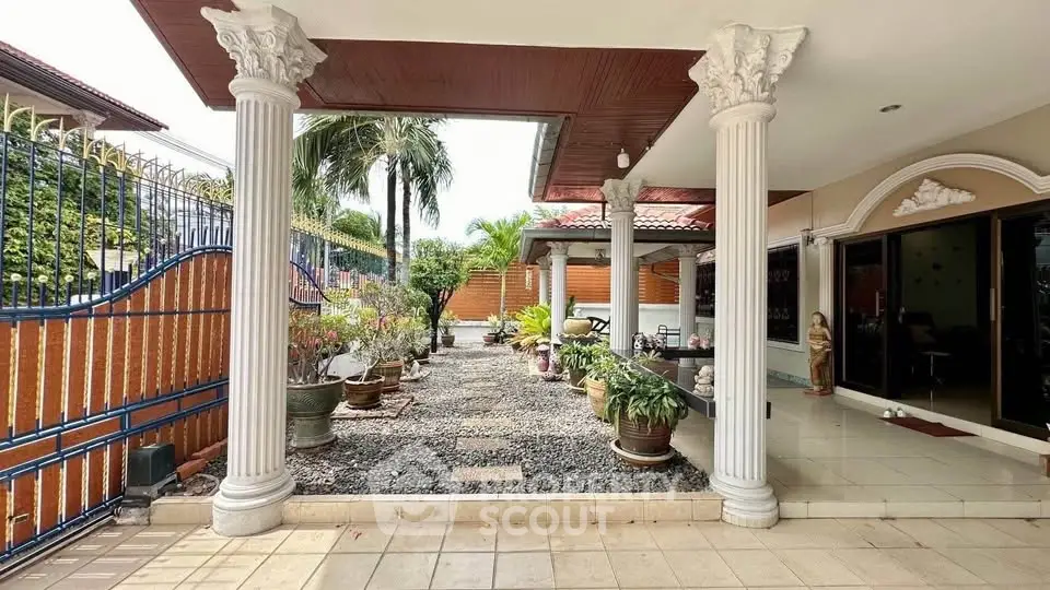 Elegant garden entrance with classical columns and lush greenery