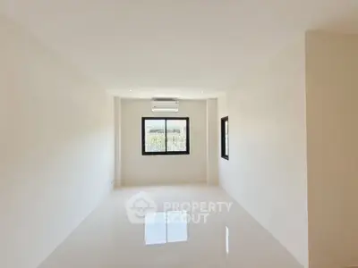 Spacious unfurnished room with large window and air conditioning, perfect for customization.