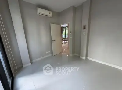 Spacious empty room with air conditioning and tiled floor, ready for customization.