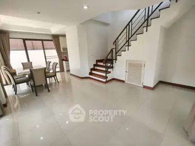 Spacious modern living room with dining area and staircase in elegant home