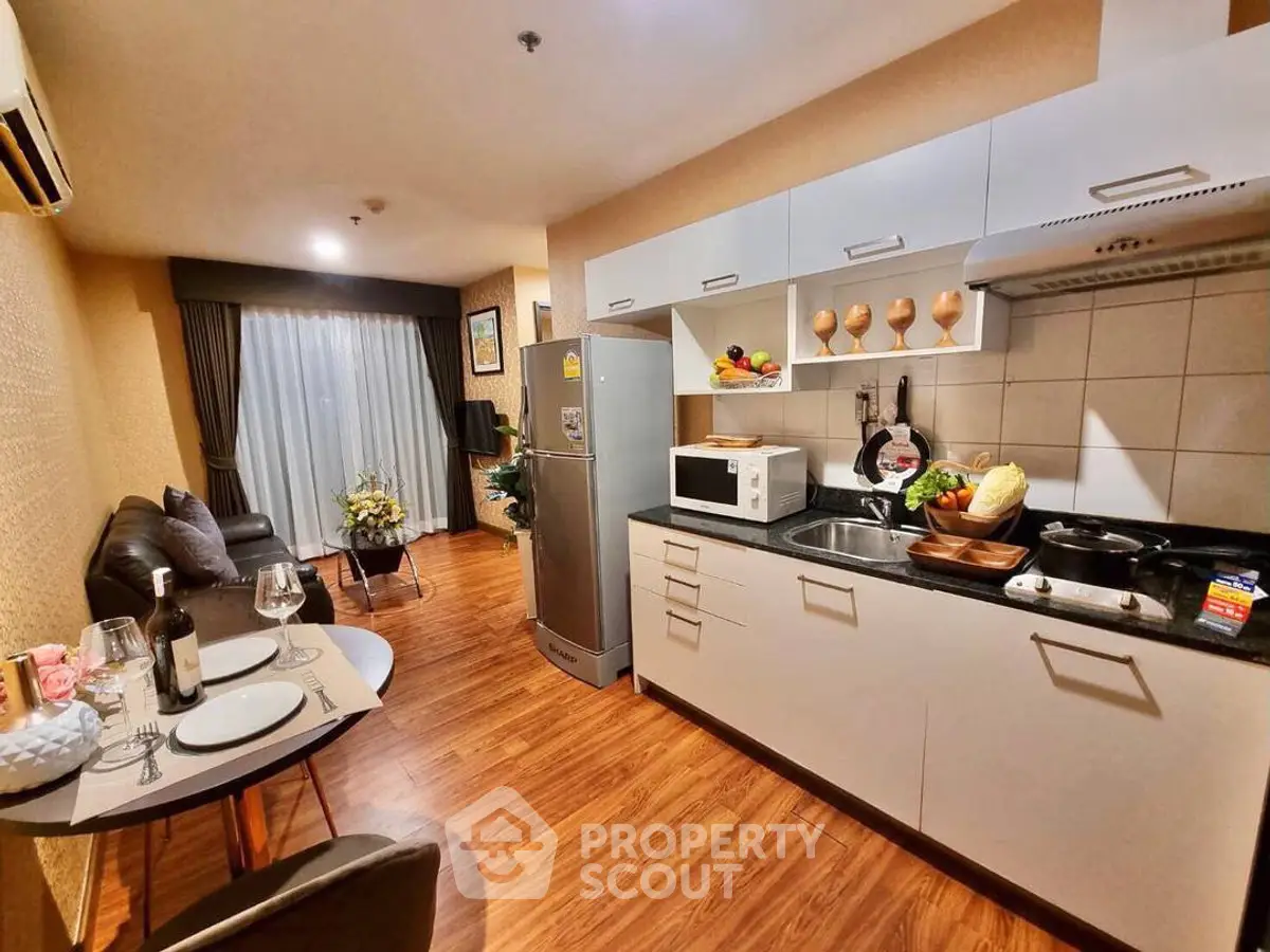 Modern kitchen and living area with sleek appliances and cozy dining setup