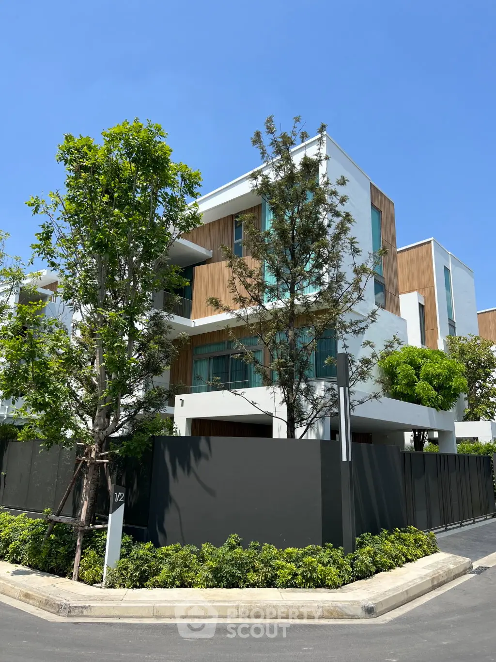 Modern architectural masterpiece with lush greenery and sleek design in a serene neighborhood.