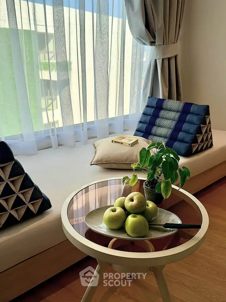 Cozy living room nook with stylish cushions and fresh apples on a modern table.