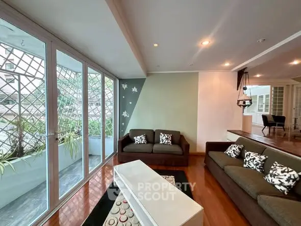 Spacious living room with large windows and modern decor in a stylish apartment.
