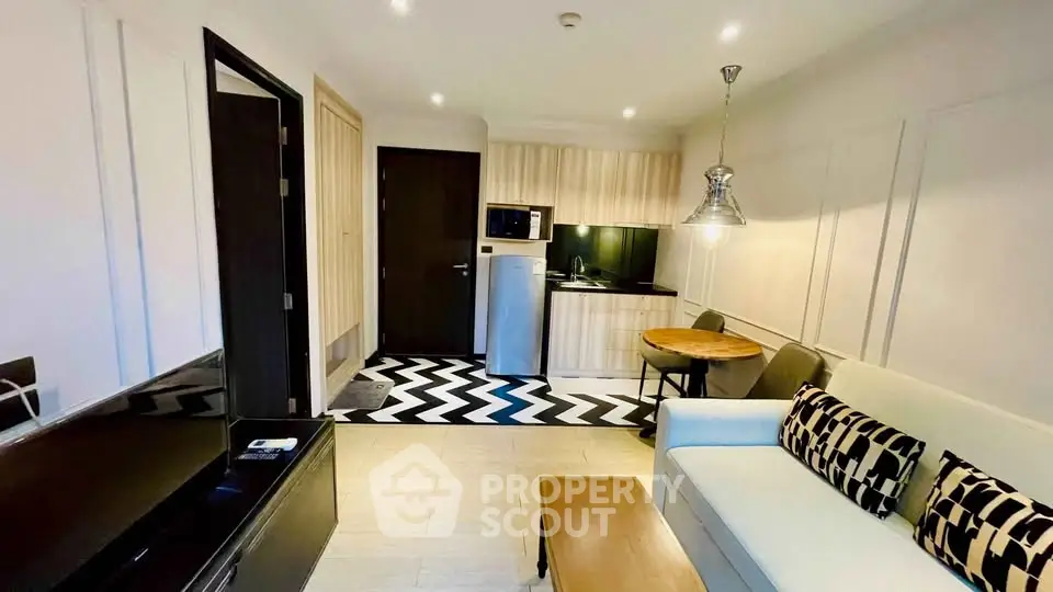 Modern living room with stylish kitchen and cozy seating area in a chic apartment.