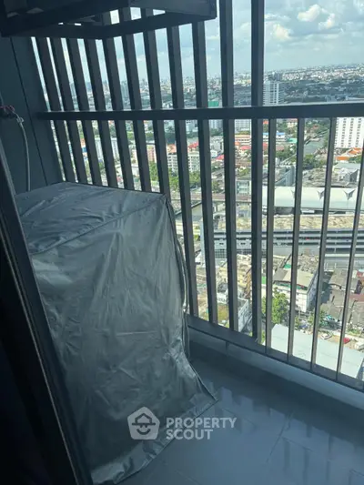 High-rise balcony with city view and covered appliance, ideal for urban living.