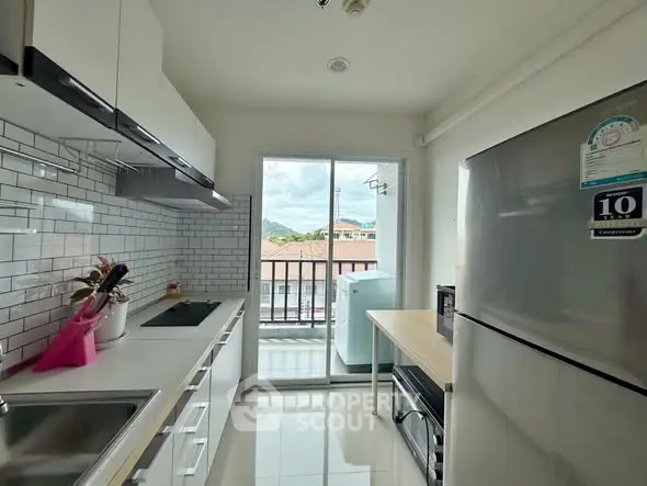 Modern kitchen with sleek appliances and balcony view