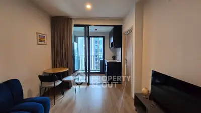 Modern living room with open kitchen and balcony view in a stylish apartment.