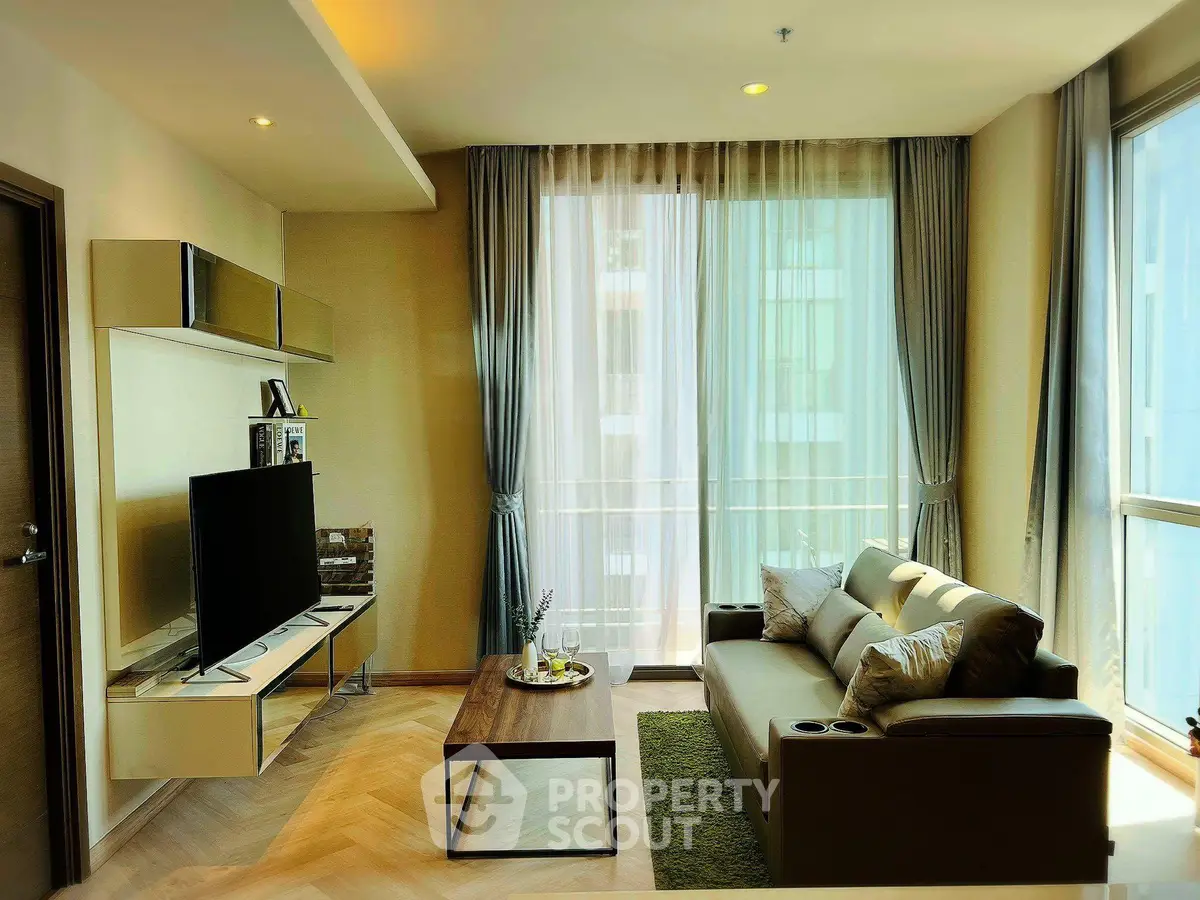 Modern living room with large windows and stylish decor in a high-rise apartment.