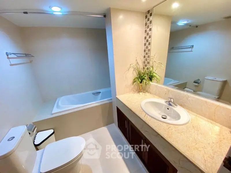 Modern bathroom with elegant fixtures and spacious bathtub in a stylish apartment.
