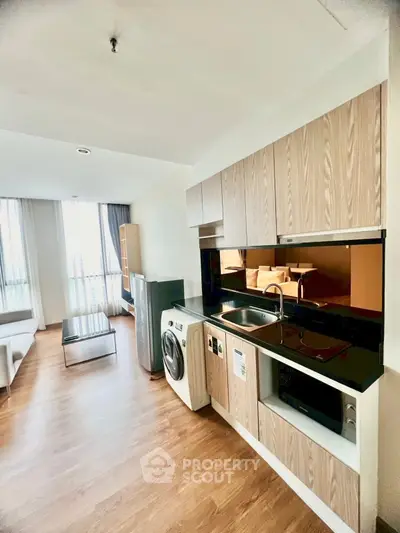Modern kitchen with open layout and washing machine in stylish apartment