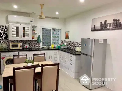 Modern kitchen with dining area, featuring washing machine and fridge, stylish backsplash, and ample storage.