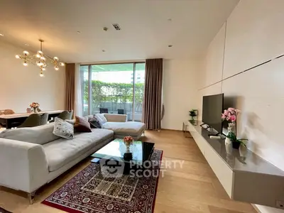 Luxurious living room with modern decor and large windows opening to a lush garden view.