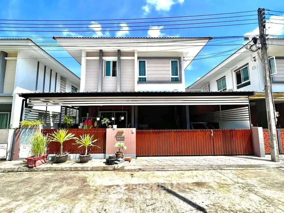 Charming two-story house with modern facade and spacious driveway in sunny neighborhood.
