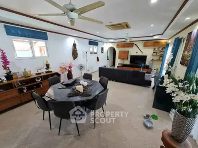Spacious living room with modern decor, ceiling fan, and ample natural light, perfect for family gatherings.