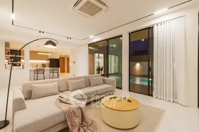 Luxurious modern living room with pool view and elegant decor.