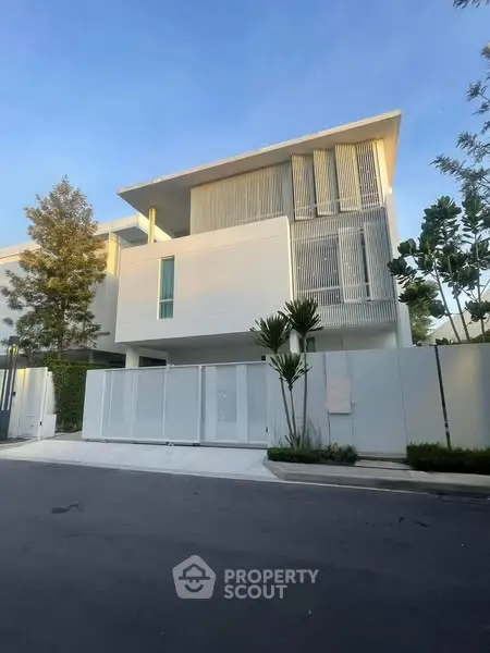 Modern minimalist white house with sleek design and lush greenery
