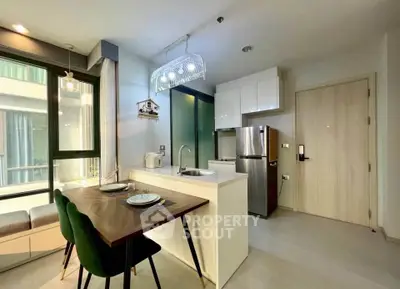 Modern kitchen with sleek design, featuring a dining area and stainless steel appliances in a bright apartment.