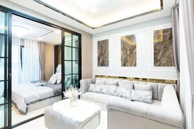 Luxurious modern living room with elegant decor and adjacent bedroom view.