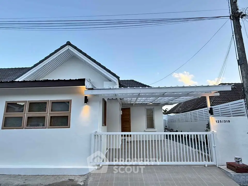 Charming single-story home with modern facade and gated driveway, perfect for family living.