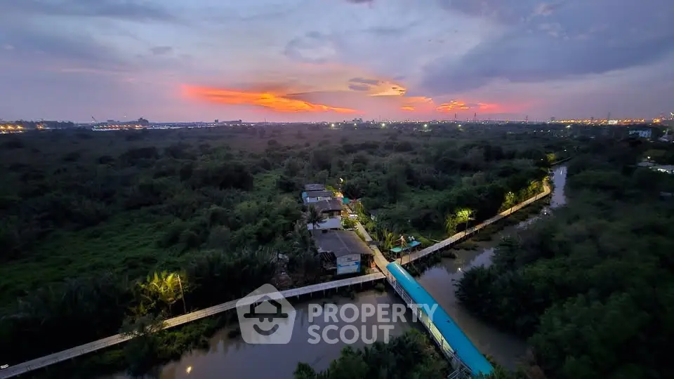 Stunning aerial view of lush greenery and waterways at sunset, perfect for serene living.