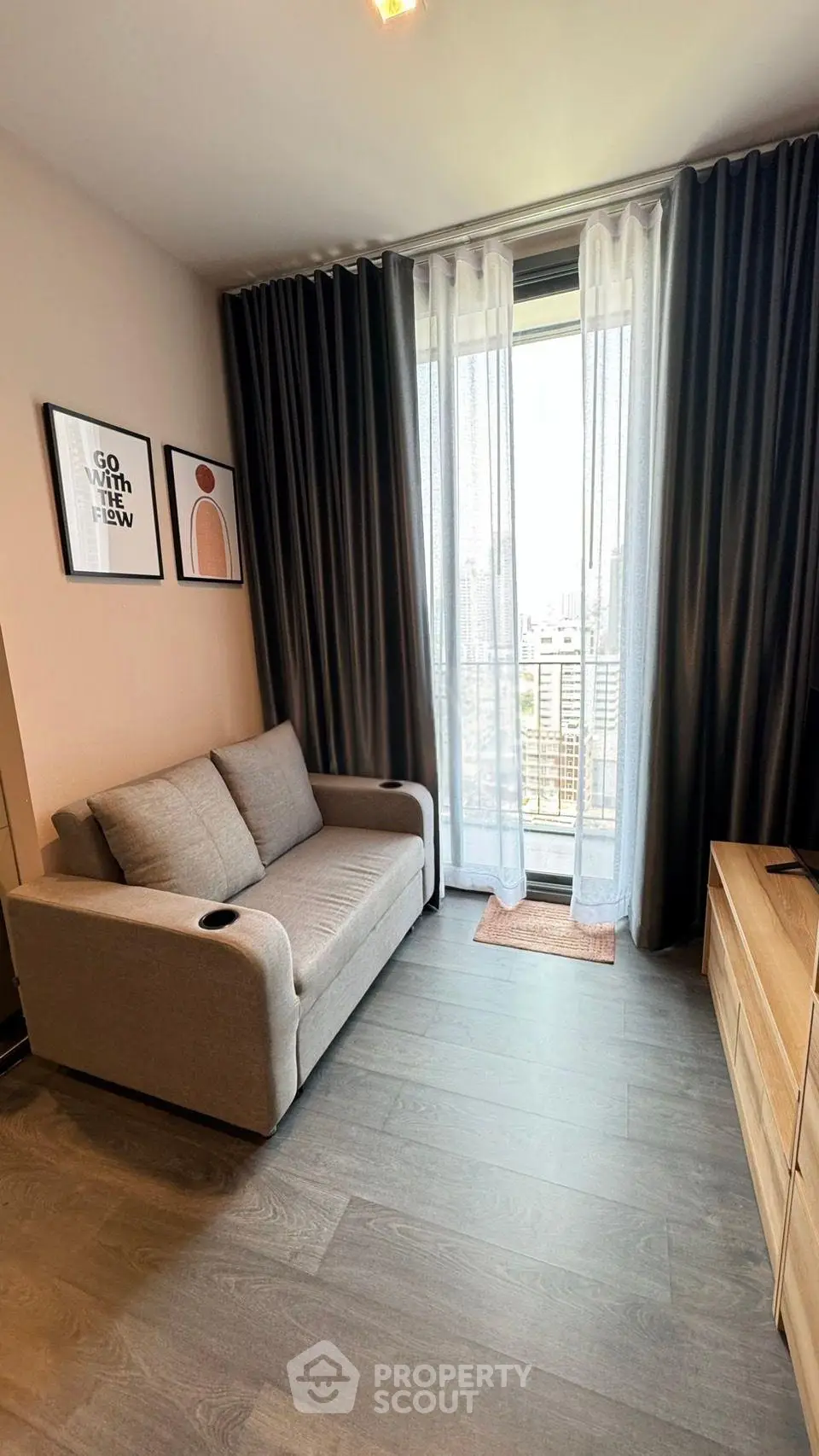 Modern living room with city view, stylish decor, and cozy seating area.