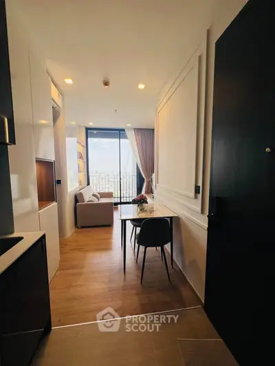 Modern apartment with open layout, featuring a cozy living area and a stunning city view from the balcony.