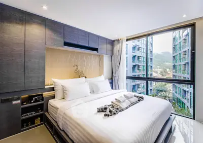 Modern bedroom with large window offering stunning city view in luxury apartment