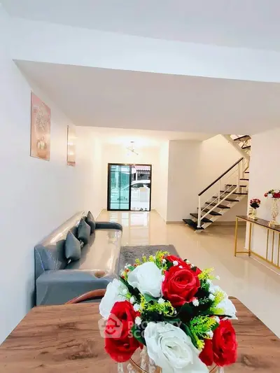 Spacious modern living room with elegant decor and stylish staircase, perfect for family gatherings.
