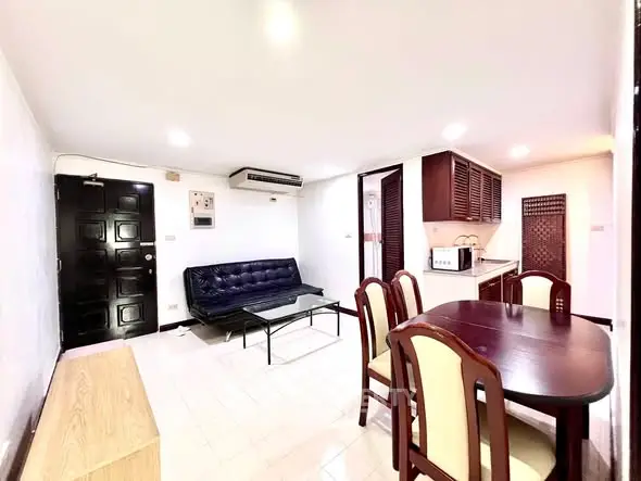 Spacious living room with dining area and modern kitchen in open layout apartment.