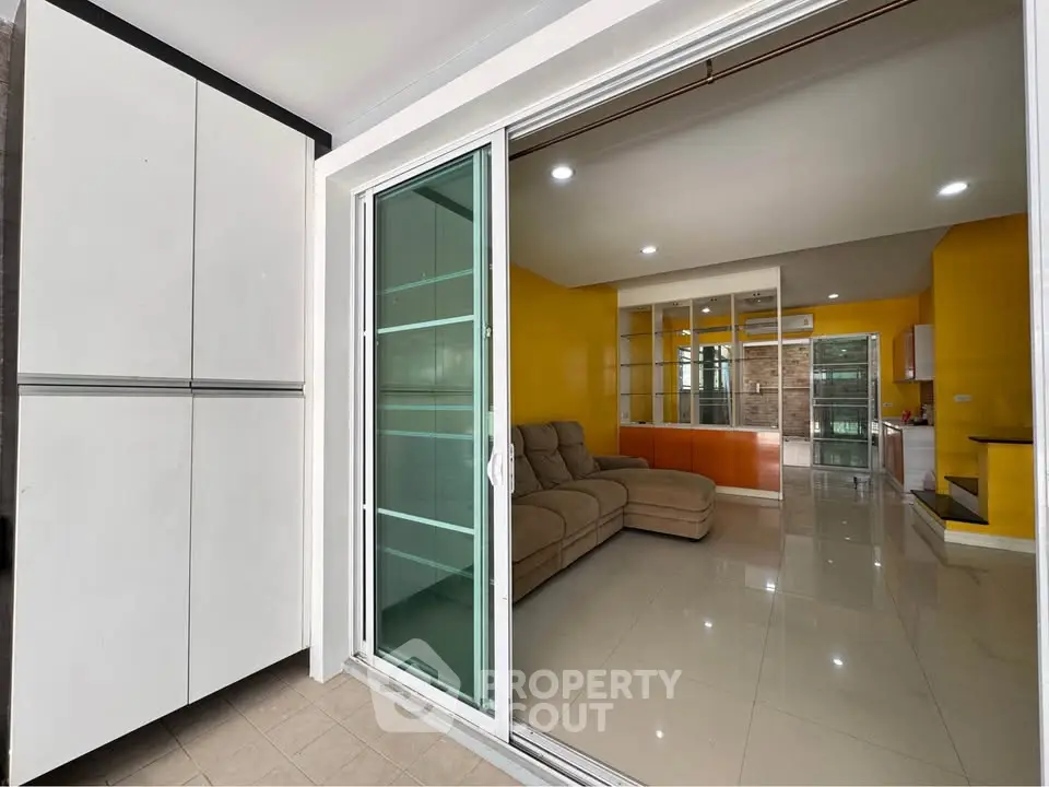 Spacious modern living room with sliding glass doors and vibrant yellow walls