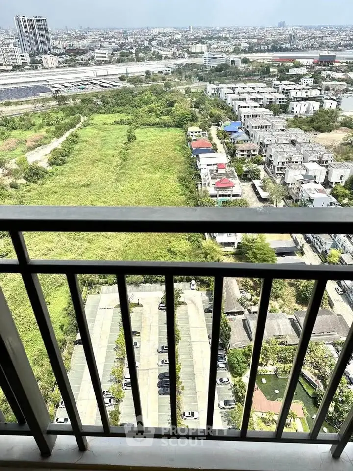 Stunning high-rise balcony view overlooking lush greenery and cityscape, perfect for urban living enthusiasts.