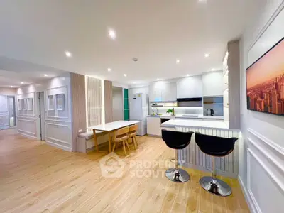 Modern open-plan kitchen and dining area with stylish decor and wooden flooring.