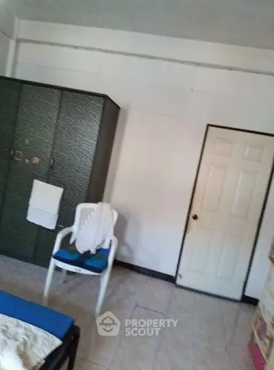 Cozy bedroom with wardrobe and chair, ideal for comfortable living.