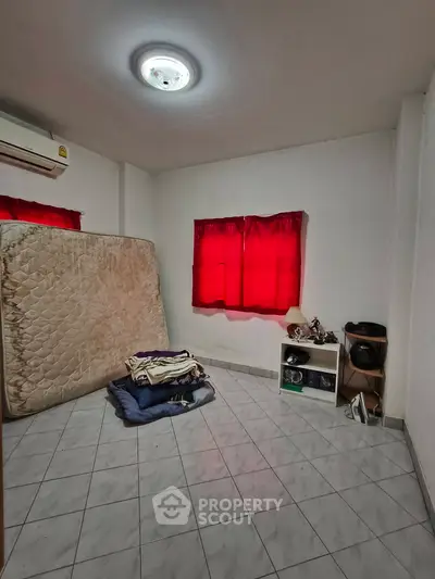 Spacious room with tiled floor, red curtains, and air conditioning, ideal for customization.