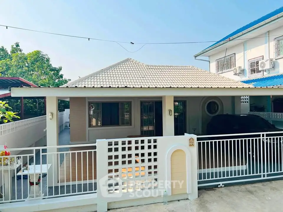 Charming single-story home with gated entrance and tiled roof in a serene neighborhood.