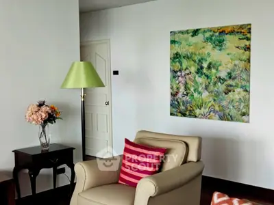 Charming living room with elegant decor and vibrant artwork, featuring a cozy armchair and stylish lamp.
