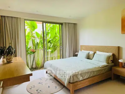 Spacious bedroom with large window and garden view, featuring modern wooden furniture and elegant decor.